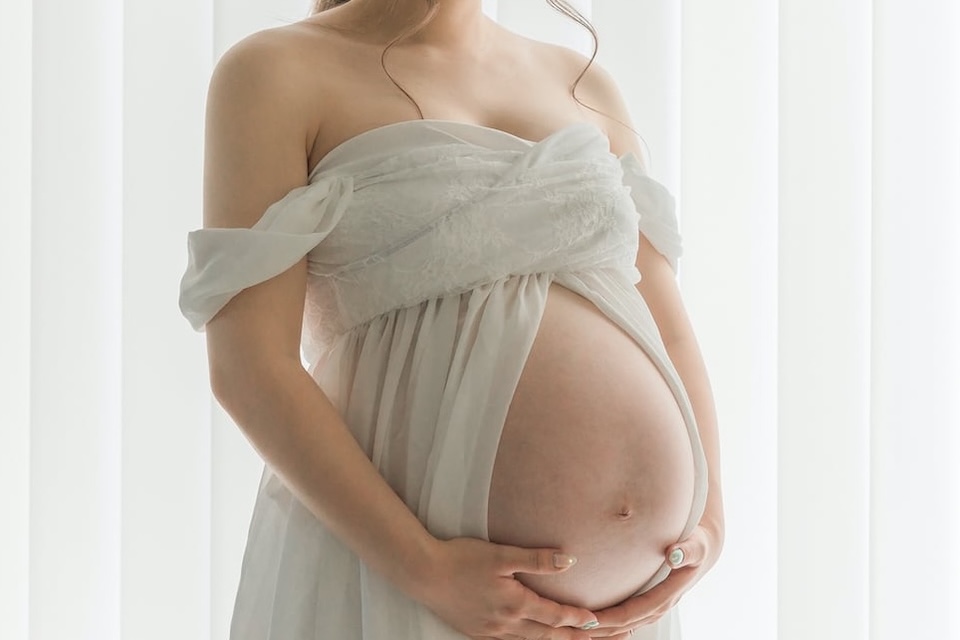 白い服を着用しお腹を出しているマタニティの写真